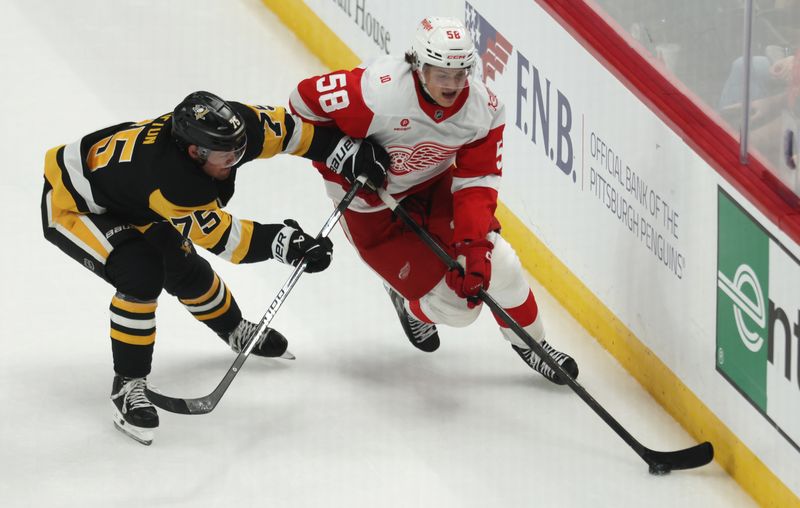 Mar 31, 2026; Pittsburgh, Pennsylvania, USA;  Detroit Red Wings center Emmitt Finnie (58) moves the puck against Pittsburgh Penguins defenseman Connor Clifton (75) during the third period at PPG Paints Arena. Mandatory Credit: Charles LeClaire-Imagn Images