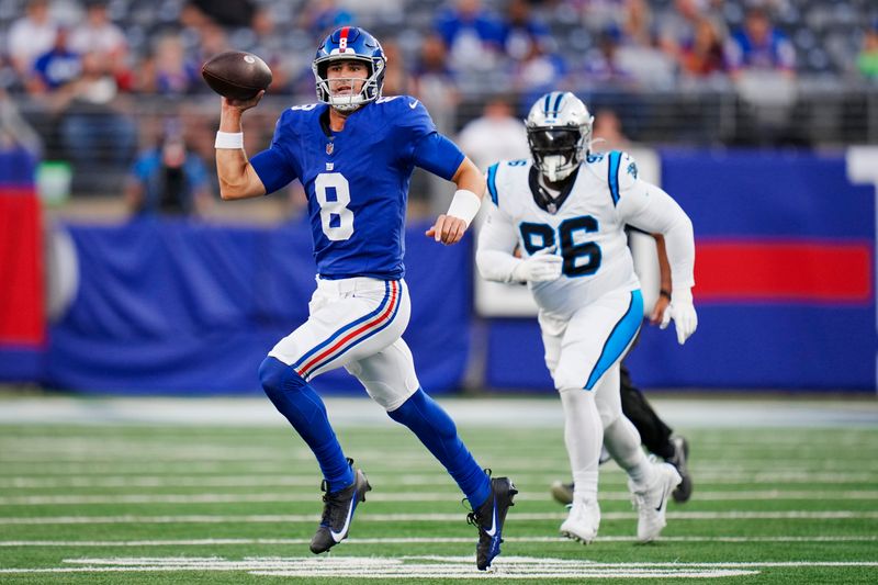 New York Giants quarterback Daniel Jones (8) looks to pass as Carolina Panthers defensive tackle DeShawn Williams (96) pursues during an NFL pre-season football game on Friday, Aug. 18, 2023, in East Rutherford, N.J. (AP Photo/Rusty Jones)