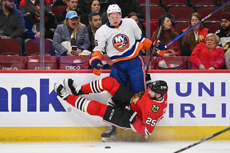 Jan 19, 2024; Chicago, Illinois, USA; Chicago Blackhawks defensman Jarred Tinordi (25) falls to the ice after checking New York Islanders forward Julien Gauthier (16) in the second period at United Center. Mandatory Credit: Jamie Sabau-USA TODAY Sports