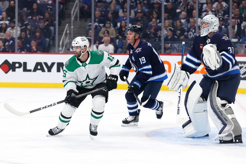 Oct 9, 2025; Winnipeg, Manitoba, CAN; Dallas Stars center Colin Blackwell (15) and Winnipeg Jets centre Jonathan Toews (19) watch the play in front of Winnipeg Jets goaltender Connor Hellebuyck (37) in the first period at Canada Life Centre. Mandatory Credit: James Carey Lauder-Imagn Images