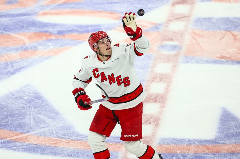 Apr 27, 2024; Elmont, New York, USA; Carolina Hurricanes defenseman Brady Skjei (76) grabs the puck in the first period against the New York Islanders in game four of the first round of the 2024 Stanley Cup Playoffs at UBS Arena. Mandatory Credit: Wendell Cruz-USA TODAY Sports