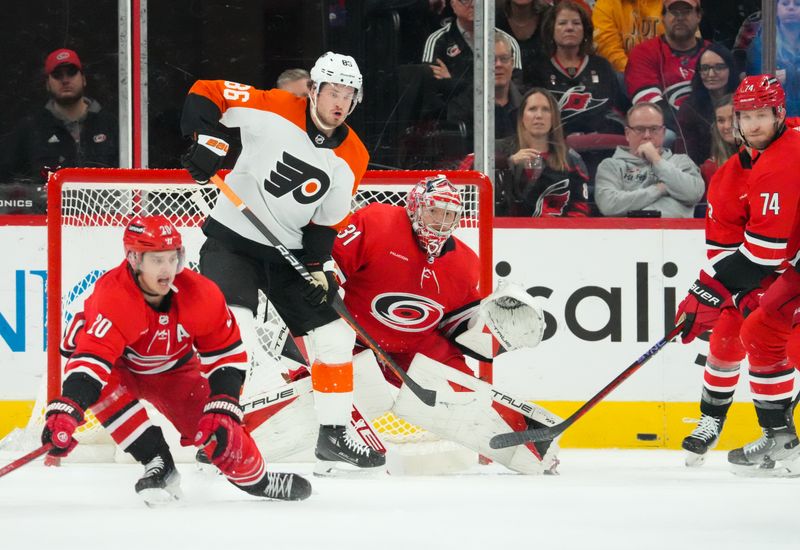 Mar 21, 2024; Raleigh, North Carolina, USA; Carolina Hurricanes goaltender Frederik Andersen (31) and Philadelphia Flyers left wing Joel Farabee (86) watch the shot during the first period at PNC Arena. Mandatory Credit: James Guillory-USA TODAY Sports