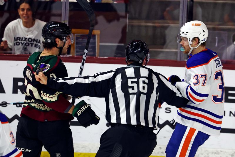 Apr 17, 2024; Tempe, Arizona, USA;  Arizona Coyotes defenseman Sean Durzi (50) and Edmonton Oilers left wing Warren Foegele (37) are separated by NHL linesman Julien Fournier (56) during the second period at Mullett Arena. Mandatory Credit: Mark J. Rebilas-USA TODAY Sports