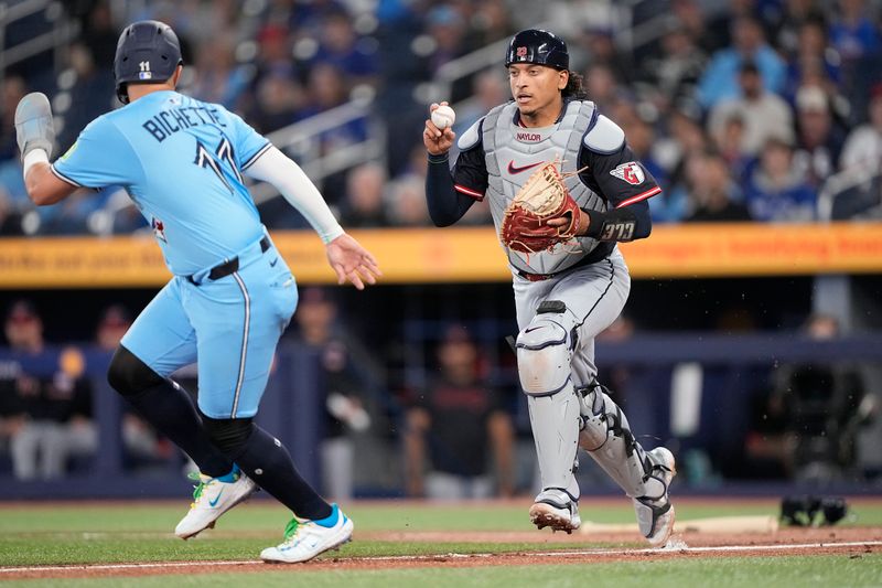 May 4, 2025; Toronto, Ontario, CAN; Cleveland Guardians catcher Bo Naylor (23) catches Toronto Blue Jays shortstop Bo Bichette (11) in a rundown at third base during the first inning at Rogers Centre. Mandatory Credit: John E. Sokolowski-Imagn Images