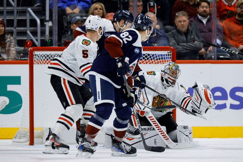 Oct 28, 2024; Denver, Colorado, USA; Chicago Blackhawks goaltender Petr Mrazek (34) deflects a shot as defenseman Connor Murphy (5) and Colorado Avalanche center Ivan Ivan (82) and right wing Nikolai Kovalenko (51) in the third period at Ball Arena. Mandatory Credit: Isaiah J. Downing-Imagn Images