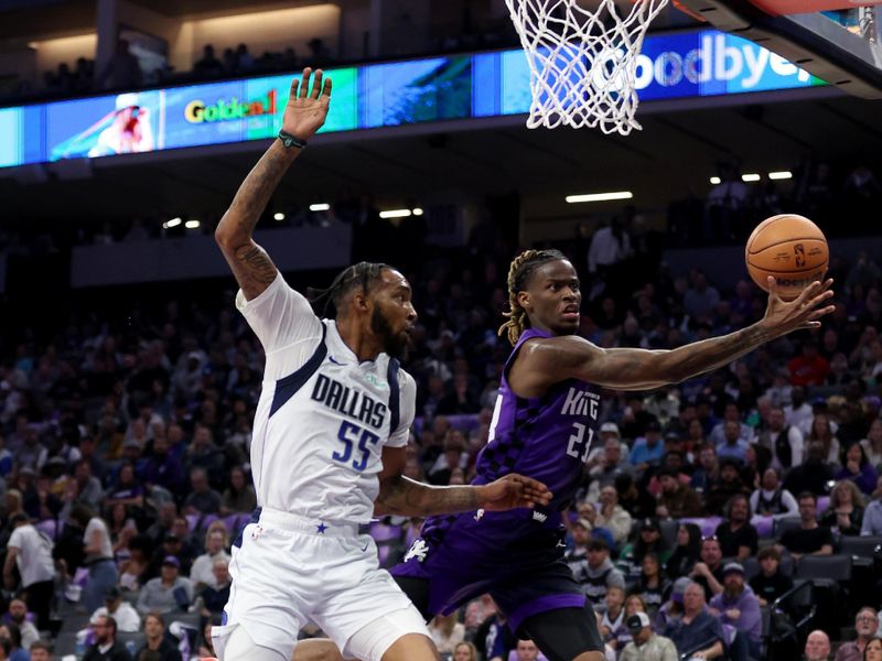 SACRAMENTO, CALIFORNIA - MARCH 26: Keon Ellis #23 of the Sacramento Kings and Derrick Jones Jr. #55 of the Dallas Mavericks go for a loose ball in the first half at Golden 1 Center on March 26, 2024 in Sacramento, California. NOTE TO USER: User expressly acknowledges and agrees that, by downloading and or using this photograph, User is consenting to the terms and conditions of the Getty Images License Agreement.  (Photo by Ezra Shaw/Getty Images)