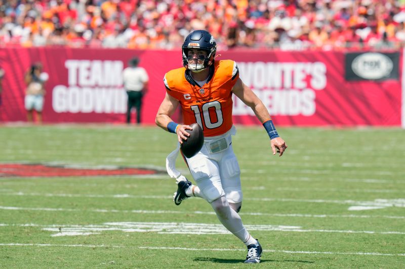 Denver Broncos quarterback Bo Nix (10) scrambles against the Tampa Bay Buccaneers during the first half of an NFL football game, in Tampa, Fla. on Sunday, Sept. 22, 2024. (AP Photo/Chris O'Meara)