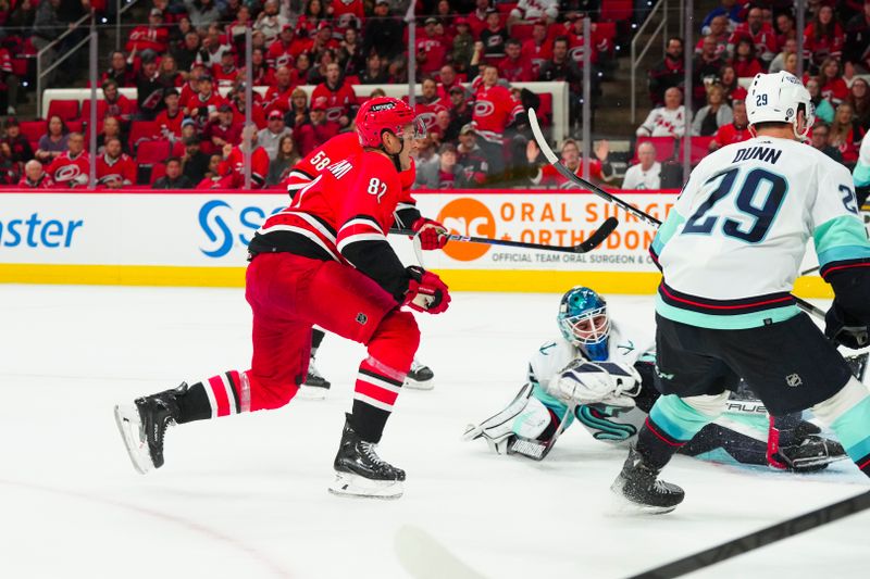 Oct 26, 2023; Raleigh, North Carolina, USA; Carolina Hurricanes center Jesperi Kotkaniemi (82) scores a goal past Seattle Kraken goaltender Joey Daccord (35) during the third period at PNC Arena. Mandatory Credit: James Guillory-USA TODAY Sports