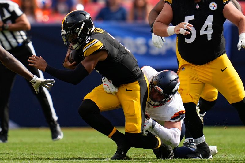 Pittsburgh Steelers quarterback Justin Fields (2) is sacked by Denver Broncos defensive end Zach Allen (99) during the first half of an NFL football game, Sunday, Sept. 15, 2024, in Denver. (AP Photo/Jack Dempsey)