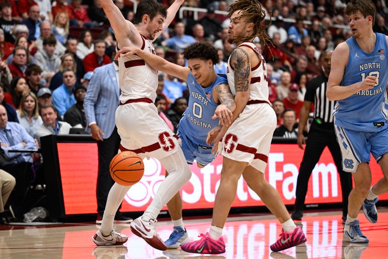 Jan 14, 2026; Stanford, California, USA; North Carolina Tar Heels guard Kyan Evans (0) looses control of the ball while dribbling against Stanford Cardinal guard Jeremy Dent-Smith (25) and forward AJ Rohosy (4) in the second half at Maples Pavilion. Mandatory Credit: Eakin Howard-Imagn Images