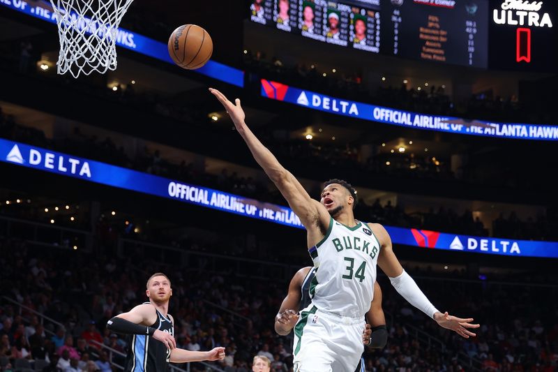 ATLANTA, GEORGIA - MARCH 30:  Giannis Antetokounmpo #34 of the Milwaukee Bucks draws a foul as he attempts a basket against Bruno Fernando #24 of the Atlanta Hawks during the second quarter at State Farm Arena on March 30, 2024 in Atlanta, Georgia.  NOTE TO USER: User expressly acknowledges and agrees that, by downloading and/or using this photograph, user is consenting to the terms and conditions of the Getty Images License Agreement.  (Photo by Kevin C. Cox/Getty Images)