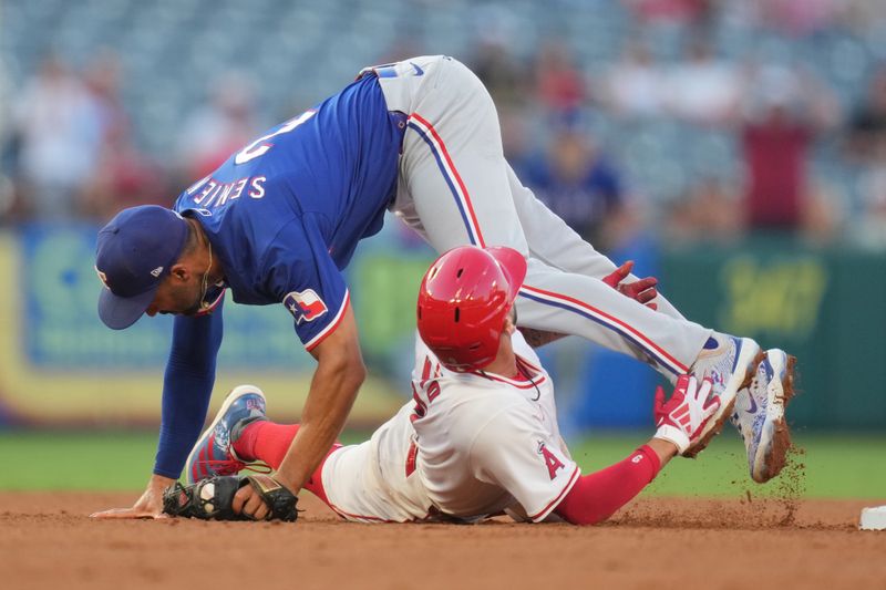 Jul 10, 2024; Anaheim, California, USA; Los Angeles Angels shortstop Zach Neto (9) is tagged out by Texas Rangers second baseman Marcus Semien (2) in the third inning  at Angel Stadium. Mandatory Credit: Kirby Lee-USA TODAY Sports