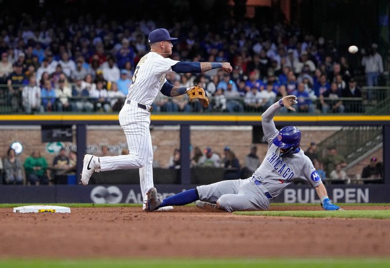 May 4, 2025; Milwaukee, Wisconsin, USA; Milwaukee Brewers shortstop Joey Ortiz (3) turns the double plays as Chicago Cubs shortstop Dansby Swanson (7) slides in to second base in the third inning at American Family Field. Mandatory Credit: Michael McLoone-Imagn Images