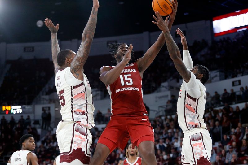 Feb 17, 2024; Starkville, Mississippi, USA; Arkansas Razorbacks forward Makhi Mitchell (15) shoots the ball against Mississippi State Bulldogs forward Jimmy Bell Jr. (15) and forward Cameron Matthews (4) during the second half at Humphrey Coliseum. Mandatory Credit: Petre Thomas-USA TODAY Sports