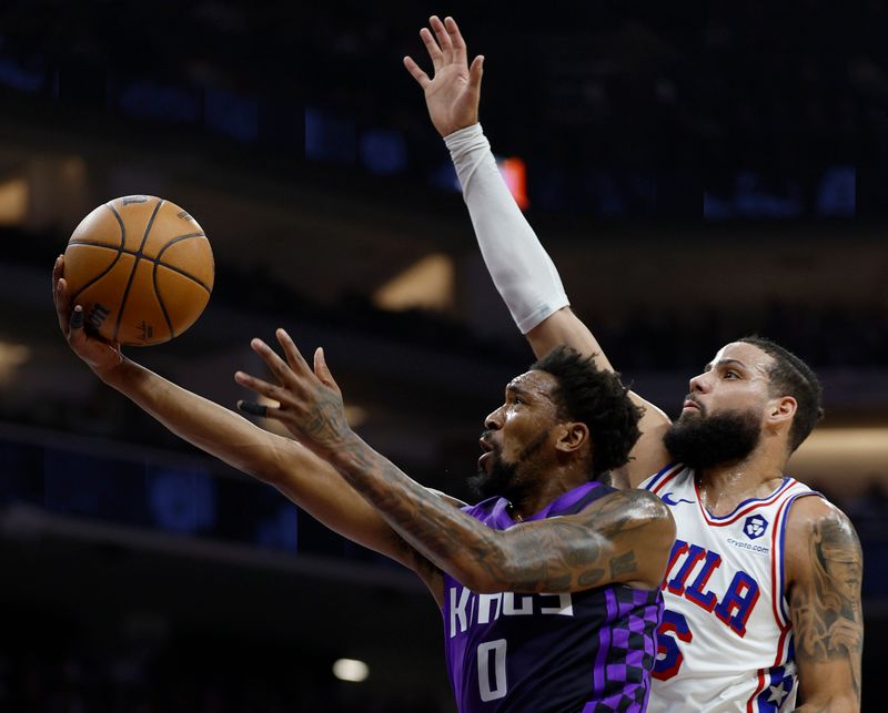 SACRAMENTO, CALIFORNIA - JANUARY 01: Malik Monk #0 of the Sacramento Kings driving to the basket shoots over Caleb Martin #16 of the Philadelphia 76ers during the first half of an NBA basketball game at Golden 1 Center on January 01, 2025 in Sacramento, California. NOTE TO USER: User expressly acknowledges and agrees that, by downloading and or using this photograph, User is consenting to the terms and conditions of the Getty Images License Agreement. (Photo by Thearon W. Henderson/Getty Images)