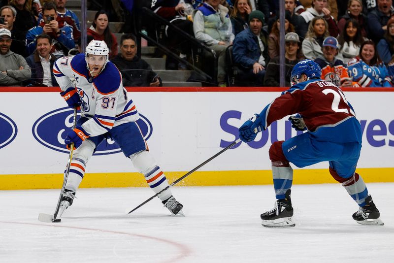 Jan 16, 2025; Denver, Colorado, USA; Edmonton Oilers center Connor McDavid (97) controls the puck as Colorado Avalanche right wing Logan O'Connor (25) defends in the third period at Ball Arena. Mandatory Credit: Isaiah J. Downing-Imagn Images