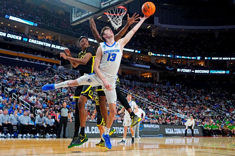 Mar 23, 2024; Pittsburgh, PA, USA; Creighton Bluejays forward Mason Miller (13) shoots the ball against Oregon Ducks center N'Faly Dante (1) and forward Kwame Evans Jr. (10) during the second half in the second round of the 2024 NCAA Tournament at PPG Paints Arena. Mandatory Credit: Gregory Fisher-USA TODAY Sports