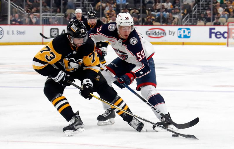 Mar 5, 2024; Pittsburgh, Pennsylvania, USA; Pittsburgh Penguins defenseman Pierre-Olivier Joseph (73) defends Columbus Blue Jackets right wing Yegor Chinakhov (59) during the second period at PPG Paints Arena. Mandatory Credit: Charles LeClaire-USA TODAY Sports