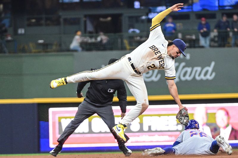 Apr 5, 2023; Milwaukee, Wisconsin, USA;  Milwaukee Brewers shortstop Willy Adames (27) attempts to tag New York Mets left fielder Tim Locastro (26) who stole second base in the eighth inning at American Family Field. Mandatory Credit: Benny Sieu-USA TODAY Sports