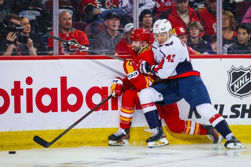 Mar 18, 2024; Calgary, Alberta, CAN; Washington Capitals defenseman Martin Fehervary (42) and Calgary Flames center Nazem Kadri (91) battles for the puck during the second period at Scotiabank Saddledome. Mandatory Credit: Sergei Belski-USA TODAY Sports