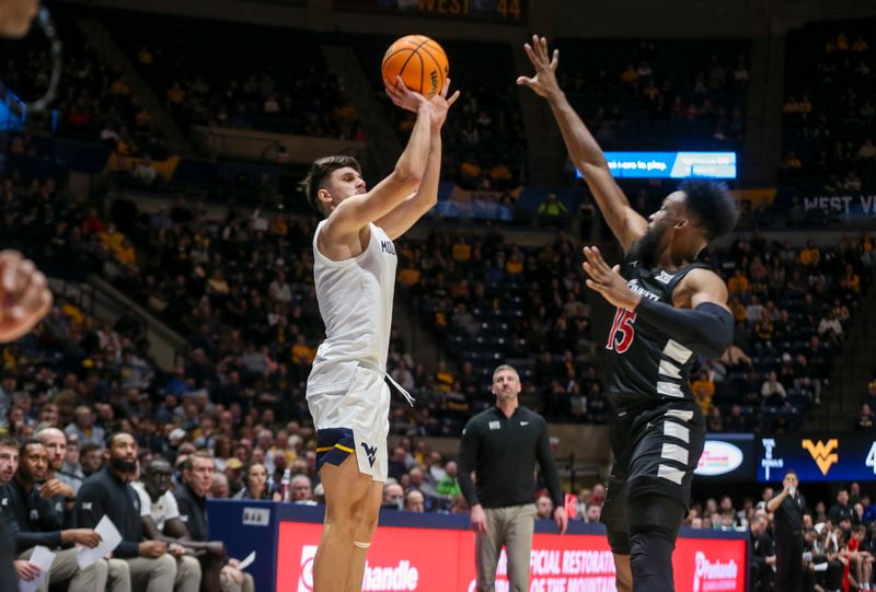 Jan 31, 2024; Morgantown, West Virginia, USA; West Virginia Mountaineers guard Kerr Kriisa (3) shoots a three pointer over Cincinnati Bearcats forward John Newman III (15) during the second half at WVU Coliseum. Mandatory Credit: Ben Queen-USA TODAY Sports