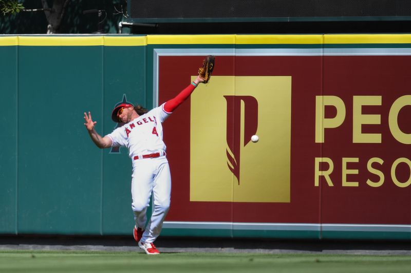 Oct 1, 2023; Anaheim, California, USA; Los Angeles Angels center fielder Brett Phillips (4) misses a catch against the Oakland Athletics during the ninth inning at Angel Stadium. Mandatory Credit: Jonathan Hui-USA TODAY Sports