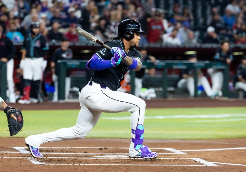 May 5, 2025; Phoenix, Arizona, USA; Arizona Diamondbacks infielder Ketel Marte hits a single in the first inning against the New York Mets at Chase Field. Mandatory Credit: Mark J. Rebilas-Imagn Images