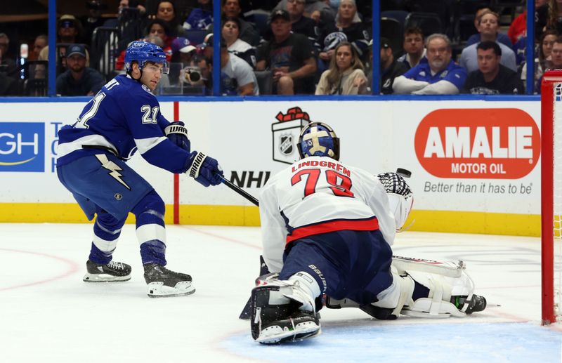 Nov 27, 2024; Tampa, Florida, USA; Tampa Bay Lightning center Brayden Point (21) shoots and scores on Washington Capitals goaltender Charlie Lindgren (79) during the first period at Amalie Arena. Mandatory Credit: Kim Klement Neitzel-Imagn Images