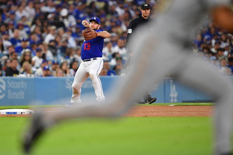 Jul 6, 2023; Los Angeles, California, USA; Los Angeles Dodgers third baseman Max Muncy (13) throws to first for the out against Pittsburgh Pirates shortstop Nick Gonzales (39) during the fifth inning at Dodger Stadium. Mandatory Credit: Gary A. Vasquez-USA TODAY Sports