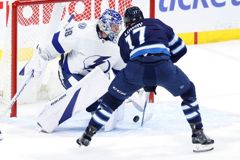 Jan 2, 2024; Winnipeg, Manitoba, CAN; Tampa Bay Lightning goaltender Andrei Vasilevskiy (88) stops a shot by Winnipeg Jets center Adam Lowry (17) in the third period at Canada Life Centre. Mandatory Credit: James Carey Lauder-USA TODAY Sports