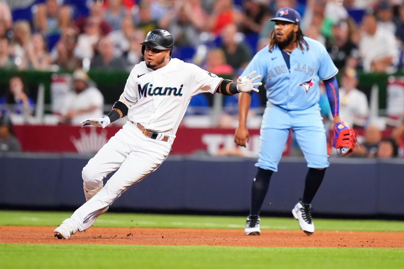 Jun 20, 2023; Miami, Florida, USA; Miami Marlins second baseman Luis Arraez (3) runs back to first base after hitting a single against the Toronto Blue Jays during the fourth inning at loanDepot Park. Mandatory Credit: Rich Storry-USA TODAY Sports