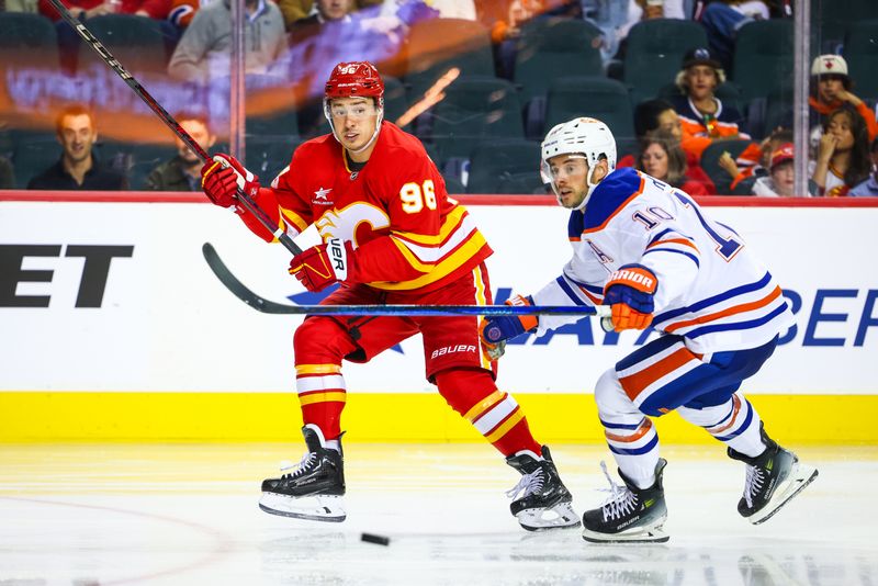 Sep 23, 2024; Calgary, Alberta, CAN; Calgary Flames left wing Andrei Kuzmenko (96) and Edmonton Oilers center Derek Ryan (10) battles for the puck during the second period at Scotiabank Saddledome. Mandatory Credit: Sergei Belski-Imagn Images