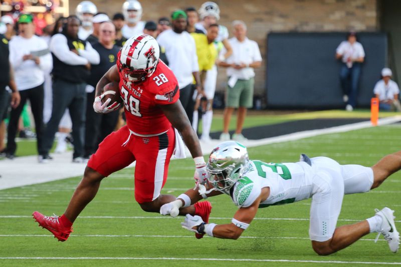 Sep 9, 2023; Lubbock, Texas, USA; Texas Tech Red Raiders running back Tahj Brooks (28) breaks a tackle by Oregon Ducks defensive back Emar rion Winston (32 in the first half  at Jones AT&T Stadium and Cody Campbell Field. Mandatory Credit: Michael C. Johnson-USA TODAY Sports