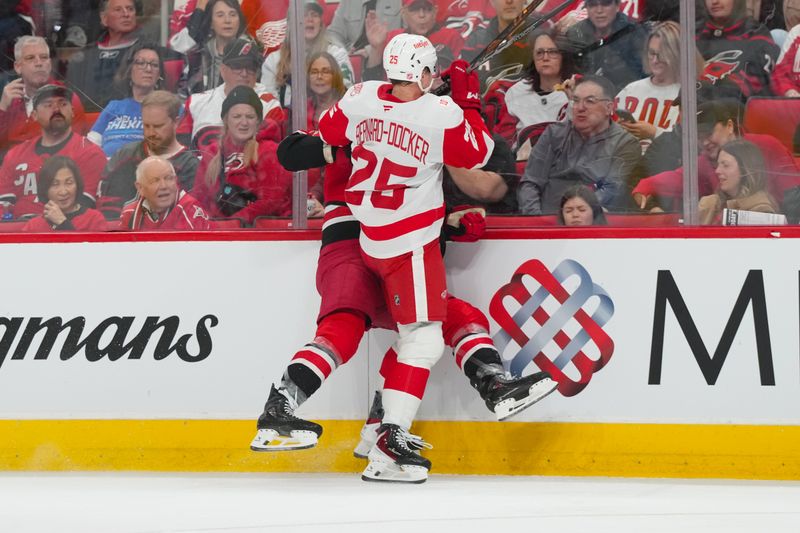 Feb 28, 2026; Raleigh, North Carolina, USA;  Detroit Red Wings defenseman Jacob Bernard-Docker (25) checks Carolina Hurricanes left wing William Carrier (28) during the first period at Lenovo Center. Mandatory Credit: James Guillory-Imagn Images