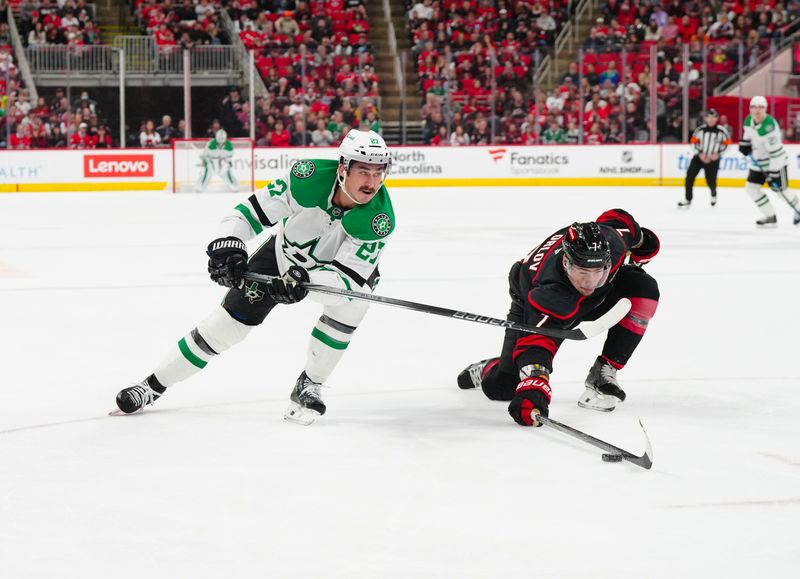 Nov 25, 2024; Raleigh, North Carolina, USA;  Carolina Hurricanes defenseman Dmitry Orlov (7) blocks the pass attempt by Dallas Stars left wing Mason Marchment (27) during the second period at Lenovo Center. Mandatory Credit: James Guillory-Imagn Images