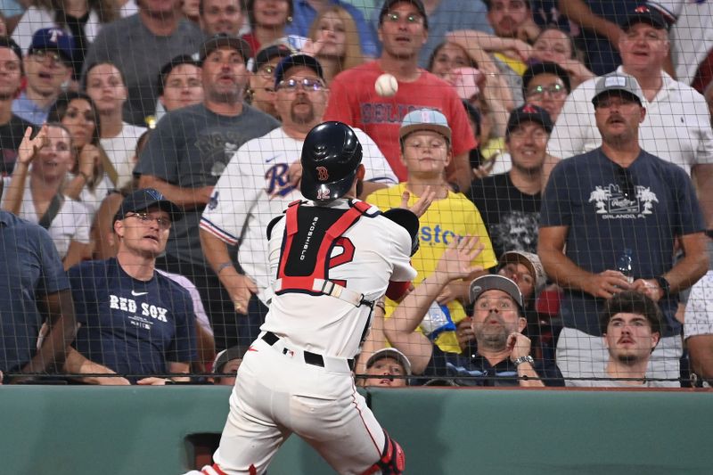 Aug 13, 2024; Boston, Massachusetts, USA; Boston Red Sox catcher Connor Wong (12) makes a catch against the Texas Rangers during the fourth inning at Fenway Park. Mandatory Credit: Eric Canha-USA TODAY Sports