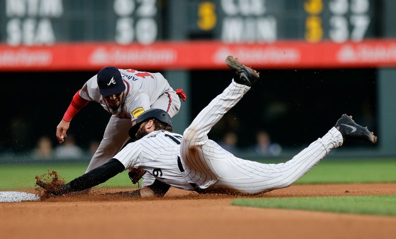 Aug 9, 2024; Denver, Colorado, USA; Colorado Rockies designated hitter Charlie Blackmon (19) advances to second ahead of a tag from Atlanta Braves shortstop Orlando Arcia (11) in the fourth inning at Coors Field. Mandatory Credit: Isaiah J. Downing-USA TODAY Sports