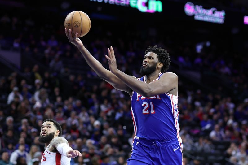 PHILADELPHIA, PENNSYLVANIA - JANUARY 15: Joel Embiid #21 of the Philadelphia 76ers shoots a lay up past Fred VanVleet #5 of the Houston Rockets during the third quarter during the third quarter at the Wells Fargo Center on January 15, 2024 in Philadelphia, Pennsylvania. NOTE TO USER: User expressly acknowledges and agrees that, by downloading and or using this photograph, User is consenting to the terms and conditions of the Getty Images License Agreement. (Photo by Tim Nwachukwu/Getty Images)