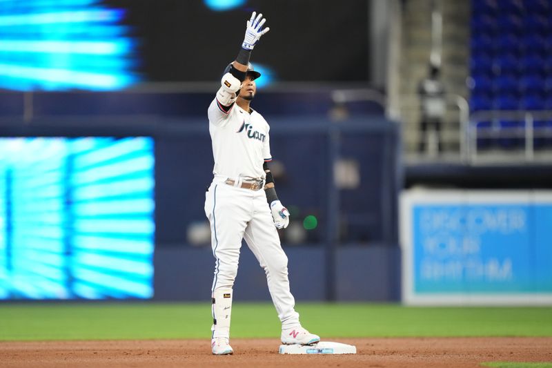 May 2, 2024; Miami, Florida, USA;  Miami Marlins second baseman Luis Arraez (3) hits a double in the first inning against the Colorado Rockies at loanDepot Park. Mandatory Credit: Jim Rassol-USA TODAY Sports