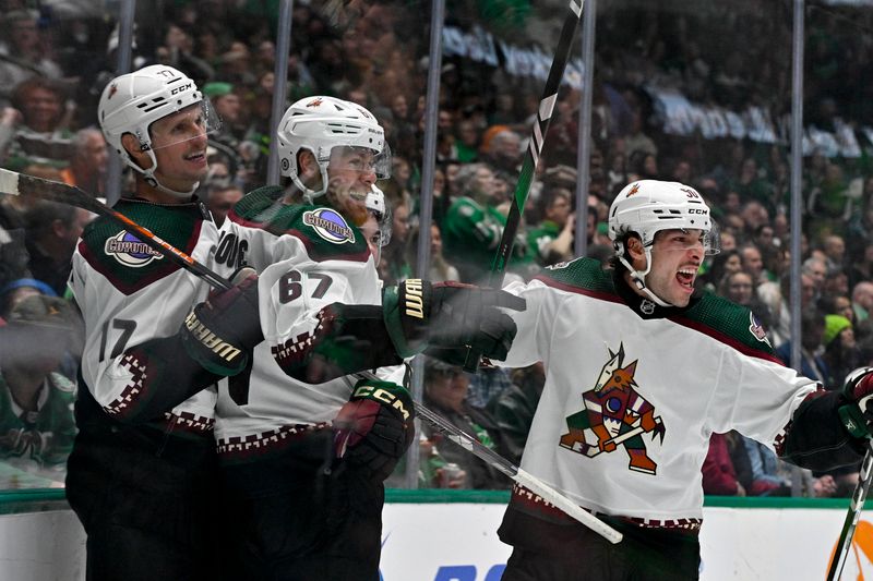 Nov 14, 2023; Dallas, Texas, USA; Arizona Coyotes left wing Lawson Crouse (67) and left wing Matias Maccelli (63) and center Nick Bjugstad (17) and defenseman Sean Durzi (50) celebrates after Crouse scores a goal against Dallas Stars goaltender Jake Oettinger (29) during the third period at the American Airlines Center. Mandatory Credit: Jerome Miron-USA TODAY Sports