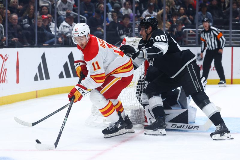 Dec 23, 2023; Los Angeles, California, USA; Calgary Flames center Mikael Backlund (11) skates with the puck during the first period against Los Angeles Kings center Pierre-Luc Dubois (80) at Crypto.com Arena. Mandatory Credit: Jessica Alcheh-USA TODAY Sports