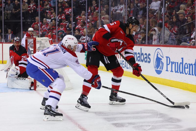 Nov 7, 2024; Newark, New Jersey, USA; New Jersey Devils defenseman Brenden Dillon (5) plays the puck against Montreal Canadiens left wing Emil Heineman (51) during the first period at Prudential Center. Mandatory Credit: Ed Mulholland-Imagn Images