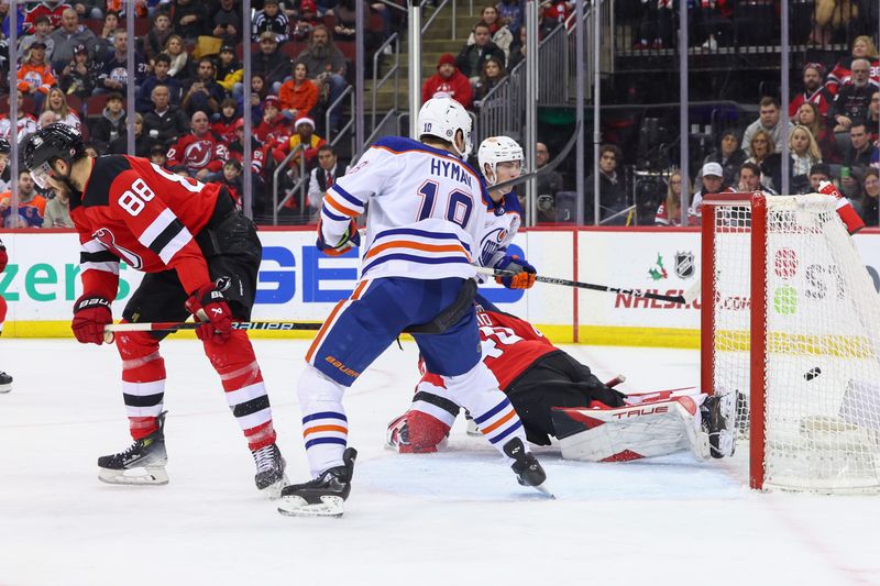 Dec 21, 2023; Newark, New Jersey, USA; Edmonton Oilers center Ryan Nugent-Hopkins (93) scores a goal on New Jersey Devils goaltender Akira Schmid (40) during the first period at Prudential Center. Mandatory Credit: Ed Mulholland-USA TODAY Sports