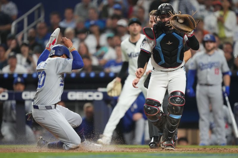 Sep 17, 2024; Miami, Florida, USA;  Los Angeles Dodgers right fielder Mookie Betts (50) scores a run in the fifth inning as Miami Marlins catcher Nick Fortes (4) fields the throw at loanDepot Park. Mandatory Credit: Jim Rassol-Imagn Images