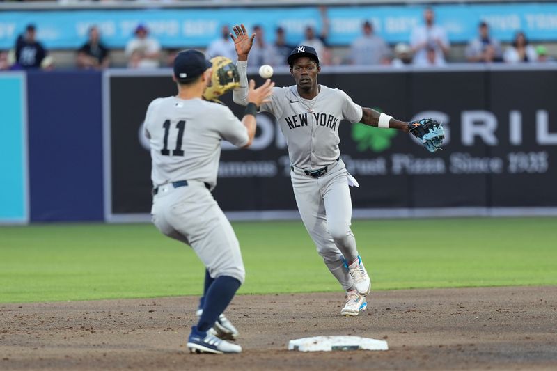Apr 18, 2025; Tampa, Florida, USA; New York Yankees third baseman Jazz Chisholm Jr. (13) tosses the ball to shortstop Anthony Volpe (11) during the second inning at George M. Steinbrenner Field. Mandatory Credit: Dave Nelson-Imagn Images
