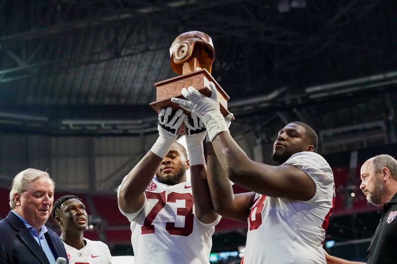 Sep 4, 2021; Atlanta, Georgia, USA; Alabama Crimson Tide offensive lineman Evan Neal (73) and defensive lineman Phidarian Mathis (48) hold up the Old Leather Helmet after defeating the Miami Hurricanes at Mercedes-Benz Stadium. Mandatory Credit: Dale Zanine-USA TODAY Sports