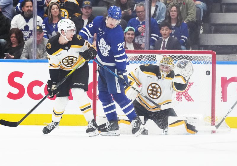 Nov 5, 2024; Toronto, Ontario, CAN; Toronto Maple Leafs left wing Matthew Knies (23) battles with Boston Bruins defenseman Brandon Carlo (25) in front of goaltender Jeremy Swayman (1) during the second period at Scotiabank Arena. Mandatory Credit: Nick Turchiaro-Imagn Imagess