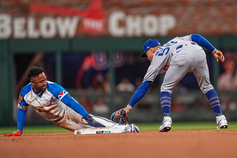 May 3, 2025; Cumberland, Georgia, USA; Atlanta Braves second baseman Ozzie Albies (1) steals second base under a tag by Los Angeles Dodgers shortstop Mookie Betts (50) during the second inning at Truist Park. Mandatory Credit: Dale Zanine-Imagn Images