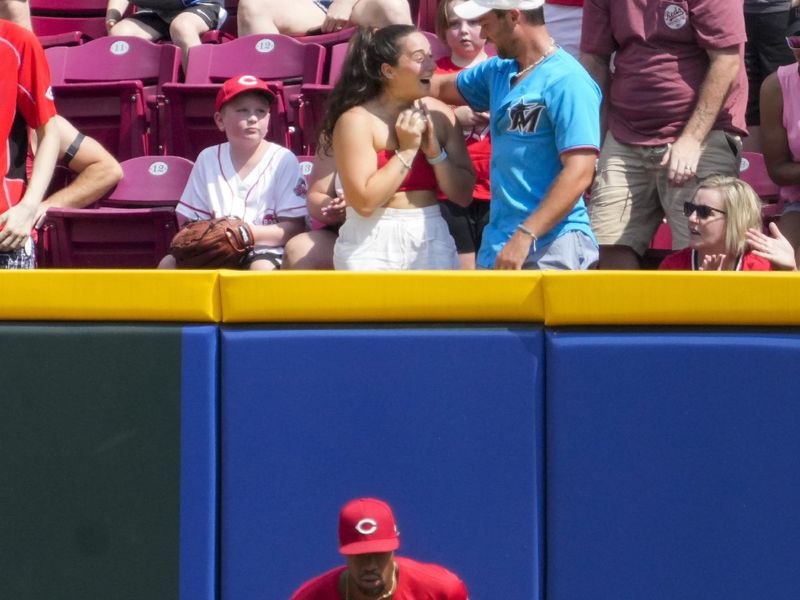 Jul 13, 2024; Cincinnati, Ohio, USA; A fan reacts after Cincinnati Reds outfielder Will Benson (30) tosses her a ball after the final out of the first inning of the MLB National League game between the Cincinnati Reds and the Miami Marlins at Great American Ball Park in downtown Cincinnati on Saturday, July 13, 2024. Mandatory Credit: Sam Greene-The Cincinnati Enquirer-USA TODAY Sports