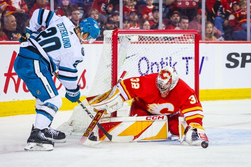 Apr 18, 2024; Calgary, Alberta, CAN; Calgary Flames goaltender Dustin Wolf (32) makes a save against San Jose Sharks left wing Fabian Zetterlund (20) during the first period at Scotiabank Saddledome. Mandatory Credit: Sergei Belski-USA TODAY Sports